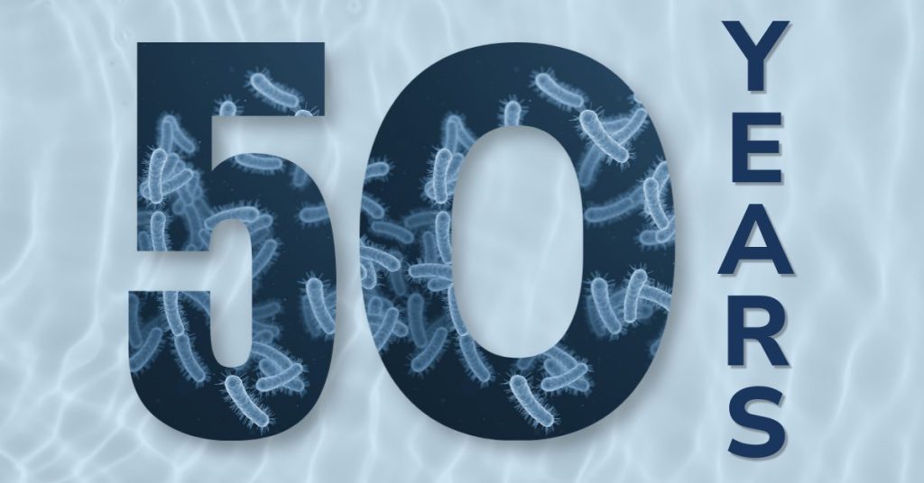 Celebration banner: large '50' filled with bacteria imagery and the word 'YEARS' written vertically on the right in blue tones.
