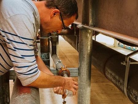 An IWC Innovations water treatment specialist collecting a water sample from a closed loop piping system. Routine water testing and system analysis are essential to identifying contamination, corrosion, and performance issues in closed loop water systems.