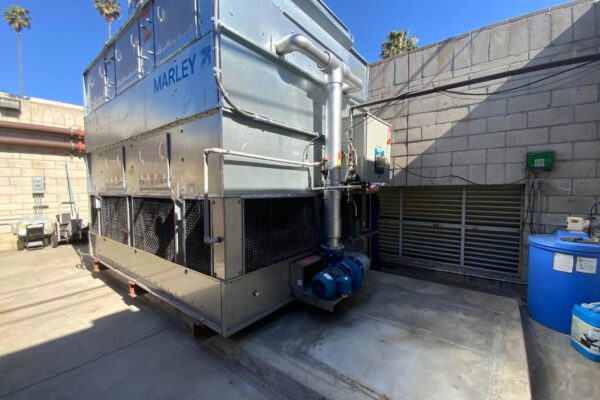 A cooling tower being serviced for Legionella prevention by IWC Innovations. Legionella is a naturally occurring bacterium commonly found in freshwater environments, but it poses the greatest health risks when it colonizes man-made systems such as cooling towers. Warm water temperatures, accumulated biofilms, and stagnant conditions can promote explosive Legionella growth.