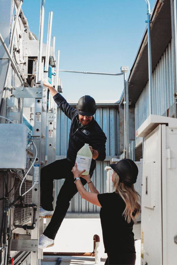 legionella-prevention-healthcare-facilities This image shows IWC Legionella experts inspecting a cooling tower at a hospital facility.