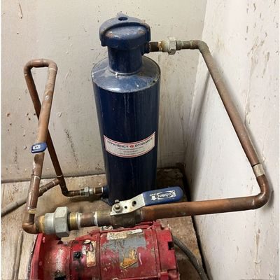 A pot feeder vessel connected to a closed loop water system in a manufacturing facility. IWC Innovations recommends pot feeder installation and chemical management to ensure precise delivery of corrosion inhibitors, biocides, and pH adjusters in closed loop water treatment programs.